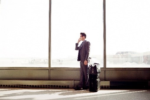 Homme attendant dans un hall avec une valise